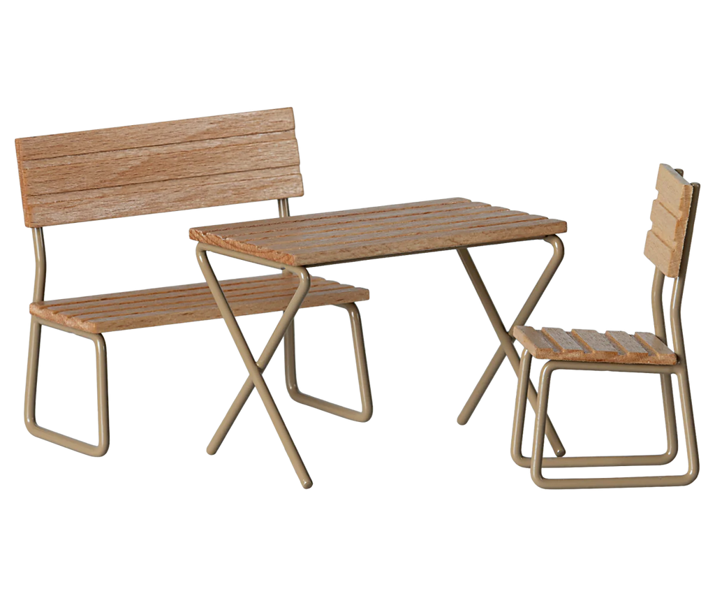 The Maileg Garden Table & Chair Set - Mouse Size includes a small wooden table with two chairs, one with a backrest and one without. Sturdy metal legs support this cozy set, and the natural wood finish creates an inviting outdoor ambiance. Ships in approximately one week.