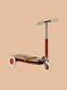 The Maileg Mouse Size Scooter, a vintage-style kickboard in red and brown, features beige handles, cream wheels, and elegant wooden details. It is set against a plain beige background and ships in approximately one week.