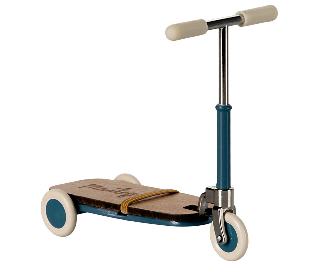 The Maileg Mouse Size Scooter / Kickboard - Blue boasts a wooden deck, blue metal frame, and white wheels. T-shaped handlebars with cream grips are elegantly secured by a tan rubber band. Shipping in approximately one week.