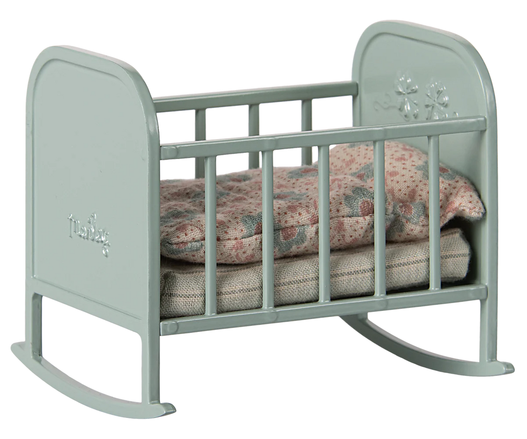 The PRE-ORDER: Maileg My Cradle - Blue Mint (ships late January) is a miniature gray metal rocking cradle with floral details on the headboard, featuring a pink-patterned cushion and blanket for added charm and comfort.