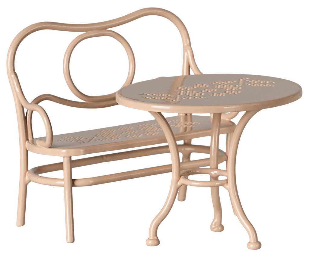 The Maileg Mouse Cafe Set, featuring a pale pink chair with a curved backrest and open circular design, includes a round table and seat with a floral pattern. Its slightly ornate legs make it perfect for an intimate afternoon tea setting.