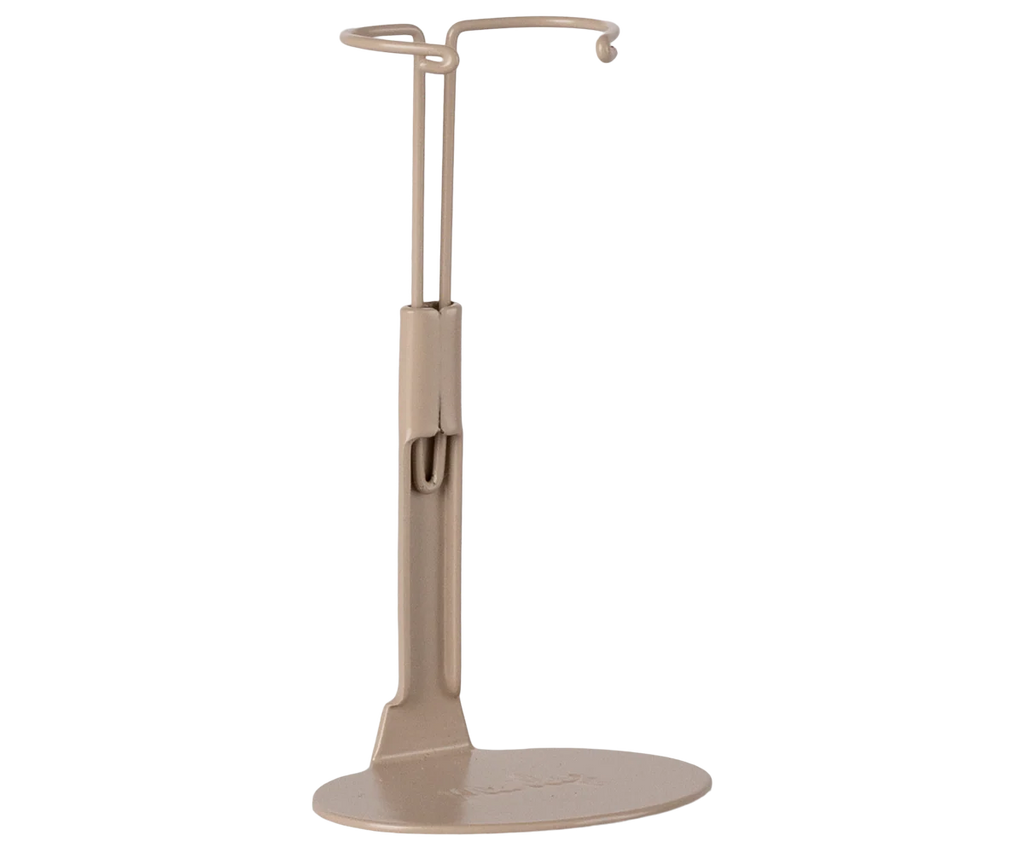 The Maileg Mouse Stand, Medium - Sand is a beige metal stand with a flat oval base and upright support ending in a circular hook, perfect for displaying your collection of headphones or similar items.