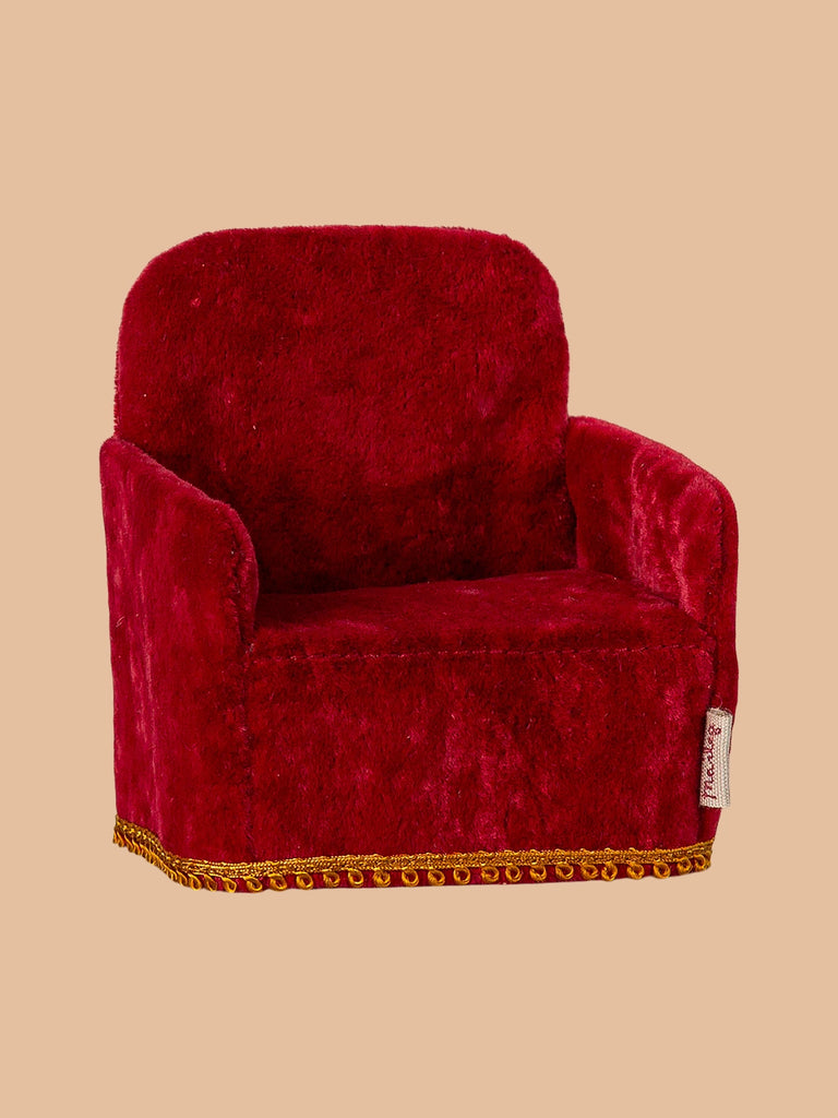 A plush red armchair with golden trim, the PRE-ORDER: Maileg Soft Chair - Red (ships late February) sits against a light brown background, ideal for hosting Maileg guests from Mouse hole Farmhouse.