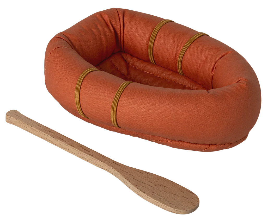 The Maileg Rubber Boat is an orange fabric toy raft with yellow bands and a small wooden paddle, shown on a white background.