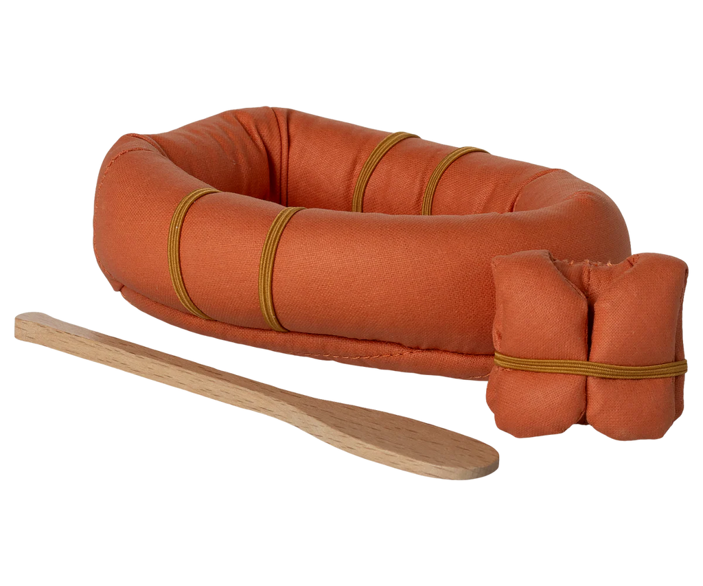 The Maileg Rubber Boat includes a small orange rubber boat with yellow bands, an orange bundle, and a wooden paddle—ideal outdoor accessories for adventurous hiker mice—shown on a white background.