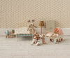 The Maileg My Babysitter - Multi Dots set features charming toy mice and baby mice, a stroller, bed, tiny wardrobe, lamp, tea set, and cradle on a soft rug—all against floral wallpaper for a cozy miniature bedroom scene.