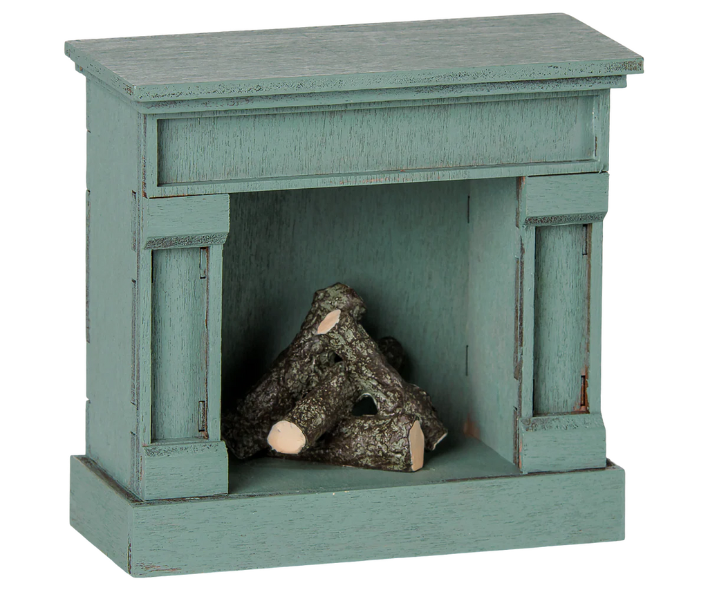 The PRE-ORDER: Maileg Fireplace, Mouse - Blue (Estimated Arrival Mid August) is a charming, vintage-style decorative fireplace with faux logs, perfect for adding cozy appeal to your miniature home.