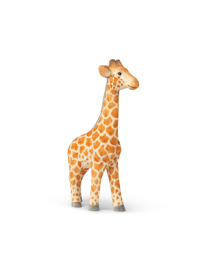 This image shows a Hand Carved Wooden Giraffe with bright orange and brown spots, standing against a background with horizontal pastel stripes, ideal for kids’ bedroom decor. The giraffe casts a small shadow on the