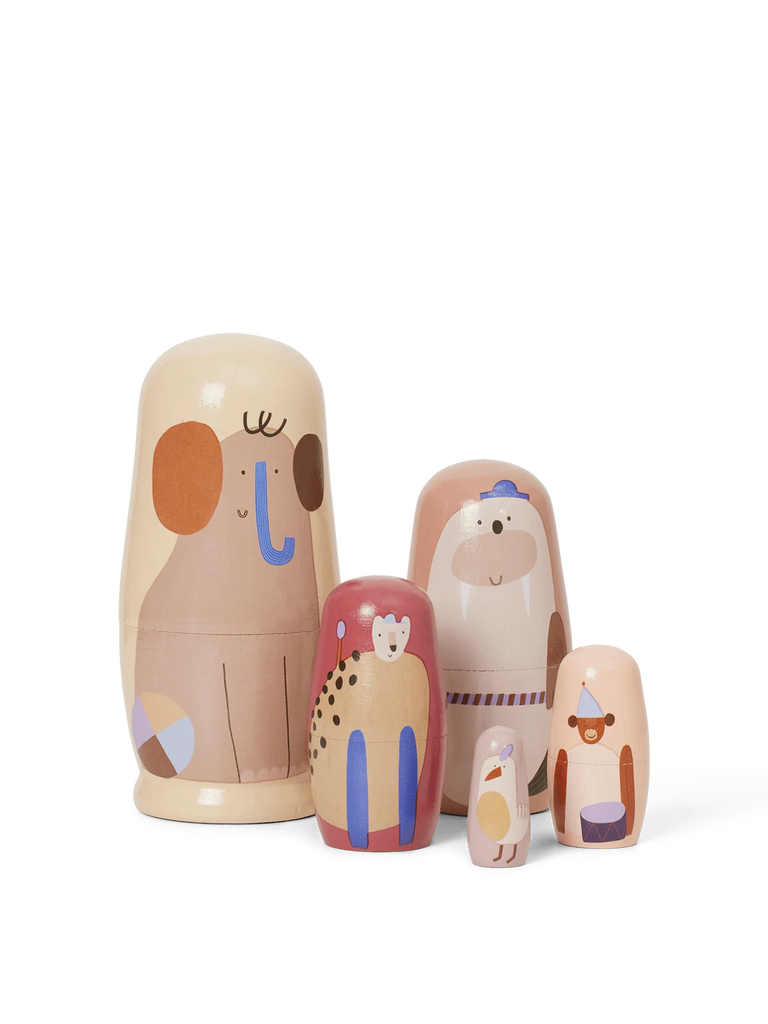 A set of five colorful Ferm Living Critter Nesting Dolls, styled like wooden animals, arranged in descending size on a black background. Each doll displays a unique, playful design and color scheme.