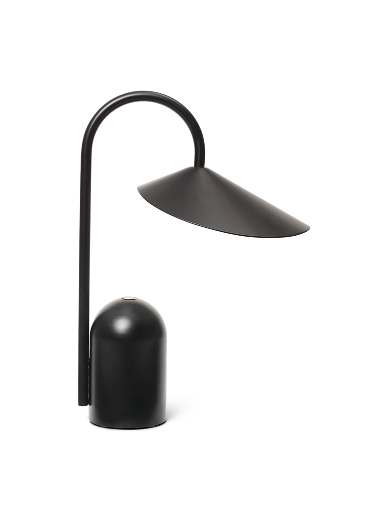 The Ferm Living Arum Portable Lamp in Black features a modern curved arm, wide angled shade, cylindrical base, and touch dimmer. This rechargeable lamp’s minimalist design adds contemporary style and convenience to any space.