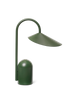 The Ferm Living Arum Portable Lamp in grass green features a modern matte finish, a curved stem, and a wide, angled cone-shaped shade, shown against a plain white background.