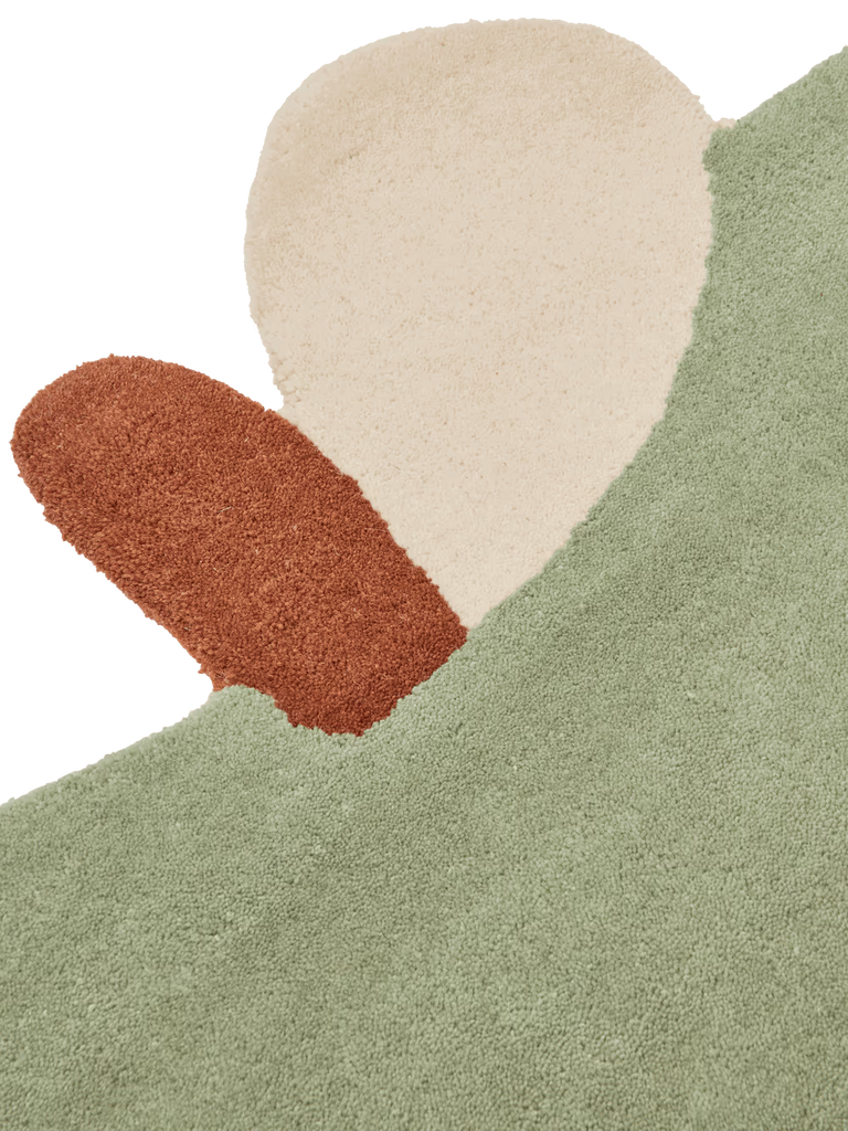 The Ferm Living Apple Tufted Rug in Tea Green features a textured New Zealand wool construction with cream and rust orange abstract shapes, evoking playful plant forms—ideal as a stylish kids playroom rug.
