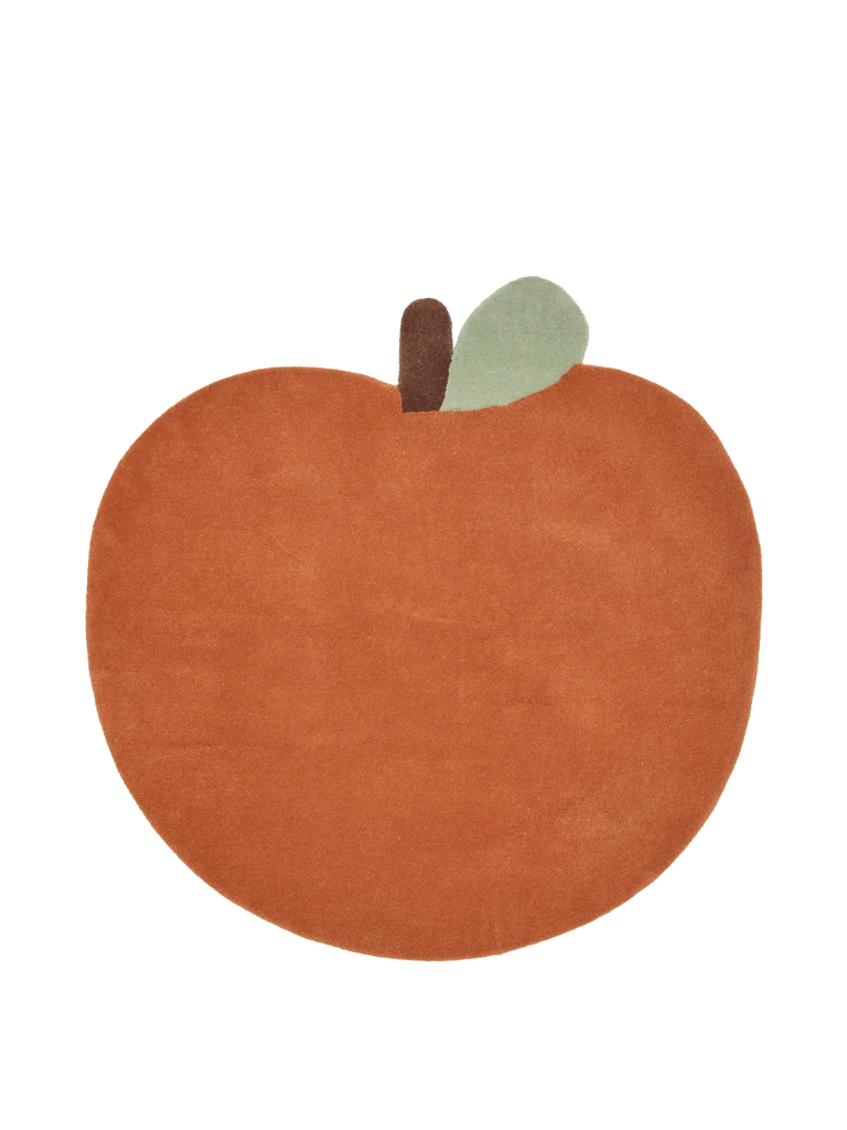 The Ferm Living Apple Tufted Rug - Brown Clay is shaped like an apple with a brown stem and green leaf, made from soft New Zealand wool—perfect as a playful kids' playroom rug against a white background.