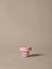 The Ferm Living Ripple Portable Lamp in Pale Rose sits centered on a plain beige background, its gentle, dimmable LED glow casting a soft shadow to the right.