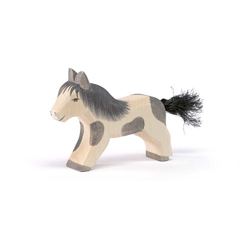 The Ostheimer Pony - Running is a handcrafted wooden toy horse with gray and beige markings, a black mane, and a black tail—perfect for fans of sustainable Ostheimer toys.