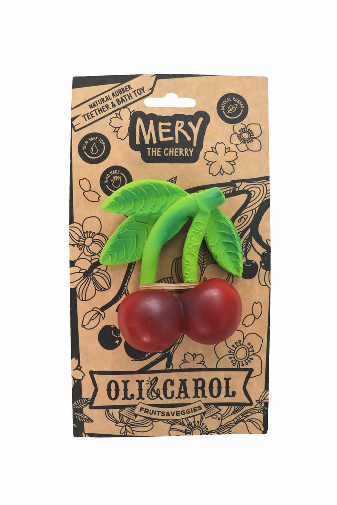 The Mery the Cherry Teether is a natural rubber baby toy shaped like two red cherries with green stems and leaves, attached to cardboard packaging labeled "Mery the Cherry" and "Oli & Carol Fruits & Veggies." Safe for teething.