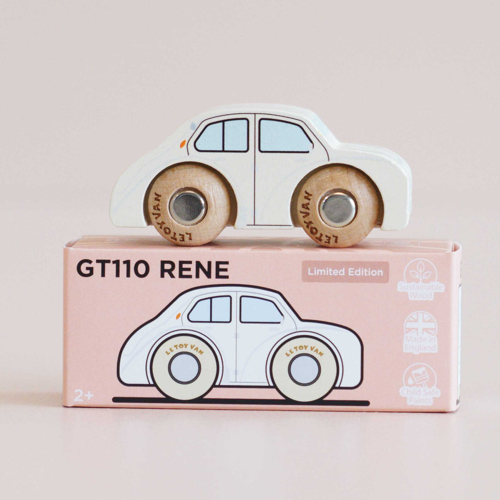 A classic toy for imaginative play, the No. 20 GT110 Rene—a white wooden car with brown wheels—sits atop a pink box labeled “GT110 RENE.” The box displays a drawing of the car along with icons indicating sustainable wood and child-safe paint, and proudly notes it is made in England.