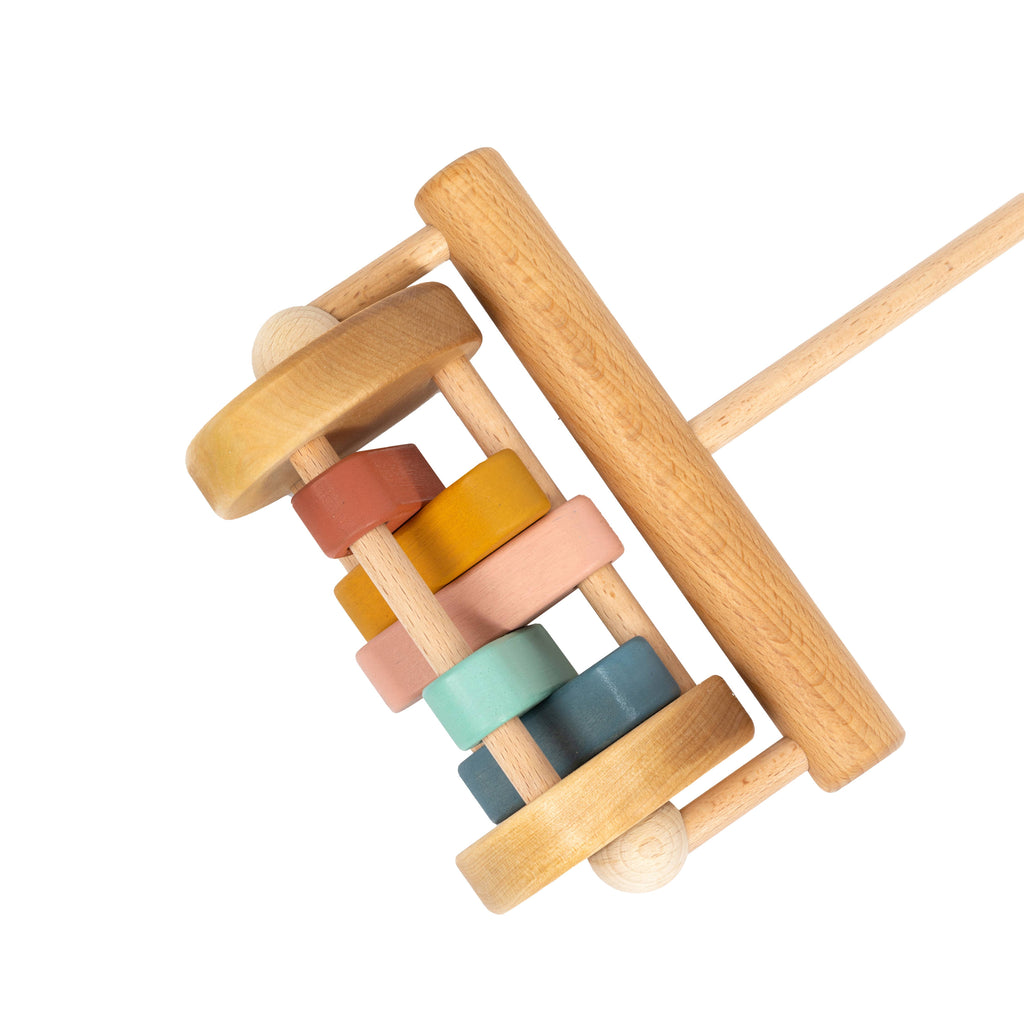 The Handmade Wooden Toy, Push Toy Rattle features a handle and five colorful spinning discs in orange, yellow, pink, teal, and blue between two large wheels—crafted from natural materials for safe and joyful play.