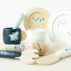 A Cutlery & Dinner Set for pretend play featuring a wooden mug, plates, a napkin ring, and toy cutlery decorated with floral and rabbit patterns.