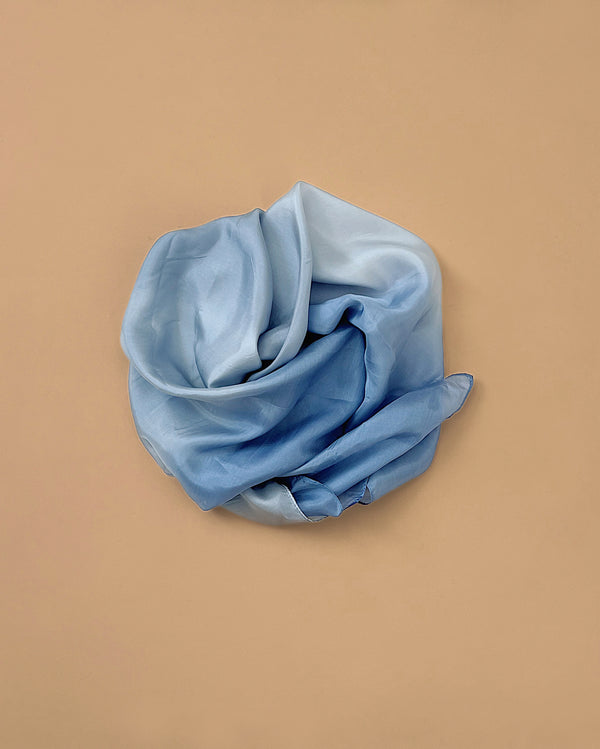 Sarah's Silks Earth Playsilk - Stone is a light blue, sheer 100% pure silk cloth, beautifully displayed in a loose circle on a beige background—ideal for creative, open-ended play.