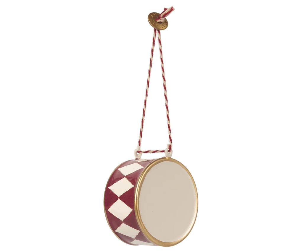 The Maileg Christmas Metal Ornament - Large Red Drum is a delightful small toy drum adorned with red and white diamond patterns and exquisite hand-painted details, suspended from a lively red and white striped cord.