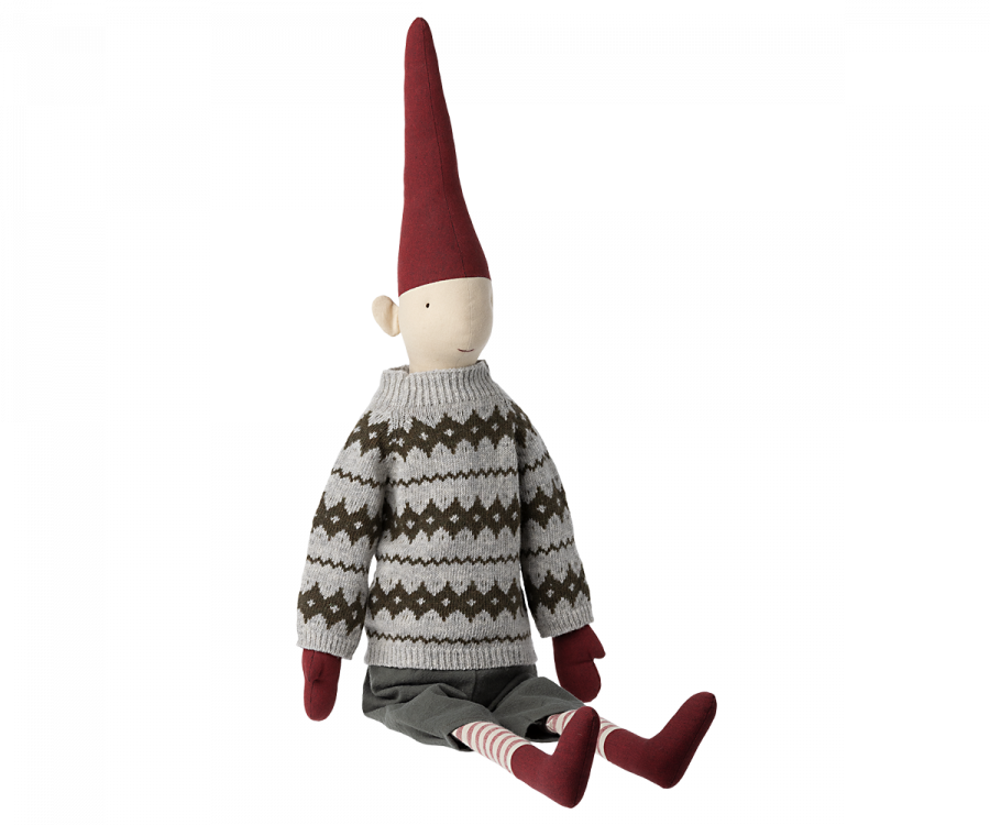 A Maileg Christmas Mega Pixy - (Size 6) with a long red hat, white and gray patterned sweater, and striped socks, sitting isolated against a black background.