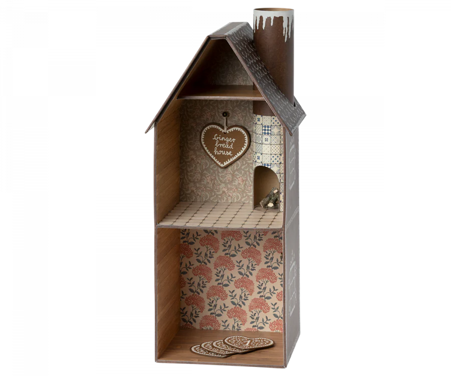 A Maileg Christmas Set featuring a two-story gingerbread house dollhouse with intricate interior wallpaper, a cozy chimney, and charming icing decorations on the exterior. Inside, a heart-shaped gingerbread sign that reads "Gingerbread House" hints at delightful holiday surprises in every room.