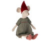 A Maileg Medium Christmas Mouse - Girl wearing a red pointed hat, green and beige plaid dress, and striped red and white leggings, sitting isolated against a black background.
