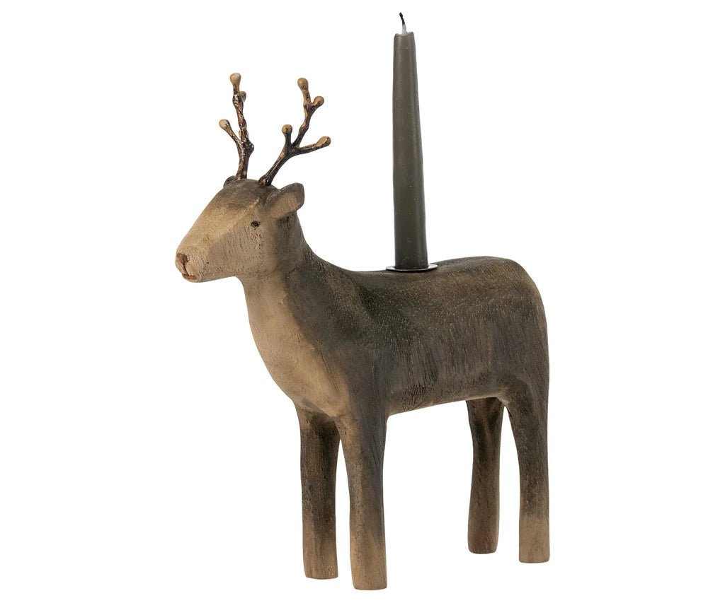 A Maileg Wooden Reindeer Candle Holder with a single black taper candle standing upright in the spot where the reindeer's back would be, isolated on a white background.