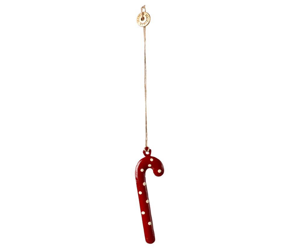 The Maileg Christmas Metal Ornament - Sugar Cane - Dot features a red candy cane with white dots, hanging from a string with a small circular tag. Hand painted for festive charm, it’s set against a plain light background.