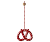 The Maileg Christmas Metal Ornament - Pretzel - Dot is a red, hand-painted pretzel-shaped ornament with white dots, hanging from a red-and-white striped string with a small gold disc—perfect as a charming Christmas tree decoration.