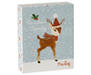 A holiday-themed gift box featuring adorable metal ornaments of the Maileg Reindeer Family illustrated with a cute reindeer wearing a red Santa hat and scarf, adorned with holly accents and snowflakes. The text includes "Reindeer Family" and "Maileg," while the light blue background enhances its festive charm.