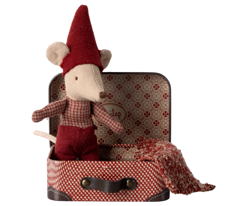 A cheerful Maileg Christmas Mouse, Baby in Suitcase, dressed in a red knit hat and outfit, is nestled in an open vintage-style travel suitcase. A warm knitted blanket decorates the patterned interior, perfectly complementing the red checkered design on the exterior.