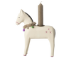 The Maileg Wooden Horse Candle Holder - Large is a classic piece featuring a beige finish with small pink stars and a tinsel garland. It is designed to hold a tall, unlit brown candle on its back, making it an ideal addition for creating a cozy Christmas atmosphere.