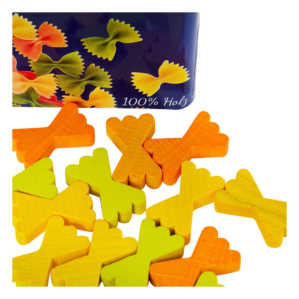 Colorful wooden pieces shaped like farfalle pasta are scattered on a white surface, with an Erzi Farfalle Pasta Pretend Food tin—featuring images of farfalle and "100% Holz"—in the background.