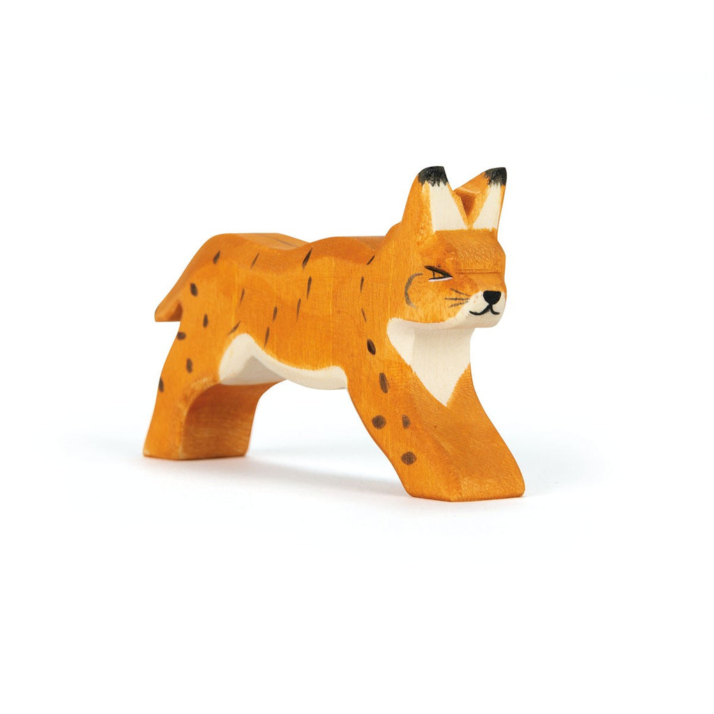 The Ostheimer Lynx Running is a handcrafted wooden toy figurine of a lynx with orange fur, black spots, and black-tipped ears in a running position. Made from sustainably sourced materials, this figure features a simplified, hand-carved design and smooth surface, showcasing detailed facial features and limbs.