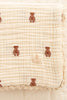 The Organic Cotton Layered Gauze Baby Blanket - Teddy (ships in one week) is a soft, cream-colored blanket with small brown teddy bear patterns, scalloped lace edging, and a sewn "NEW ORGANIC Sense of Place" label on the corner.