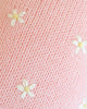 Close-up of Cuddle + Kind Sophia the Pony’s soft pink knitted fabric, handmade in Peru and adorned with small white embroidered flowers with yellow centers for a delicate, cozy look.