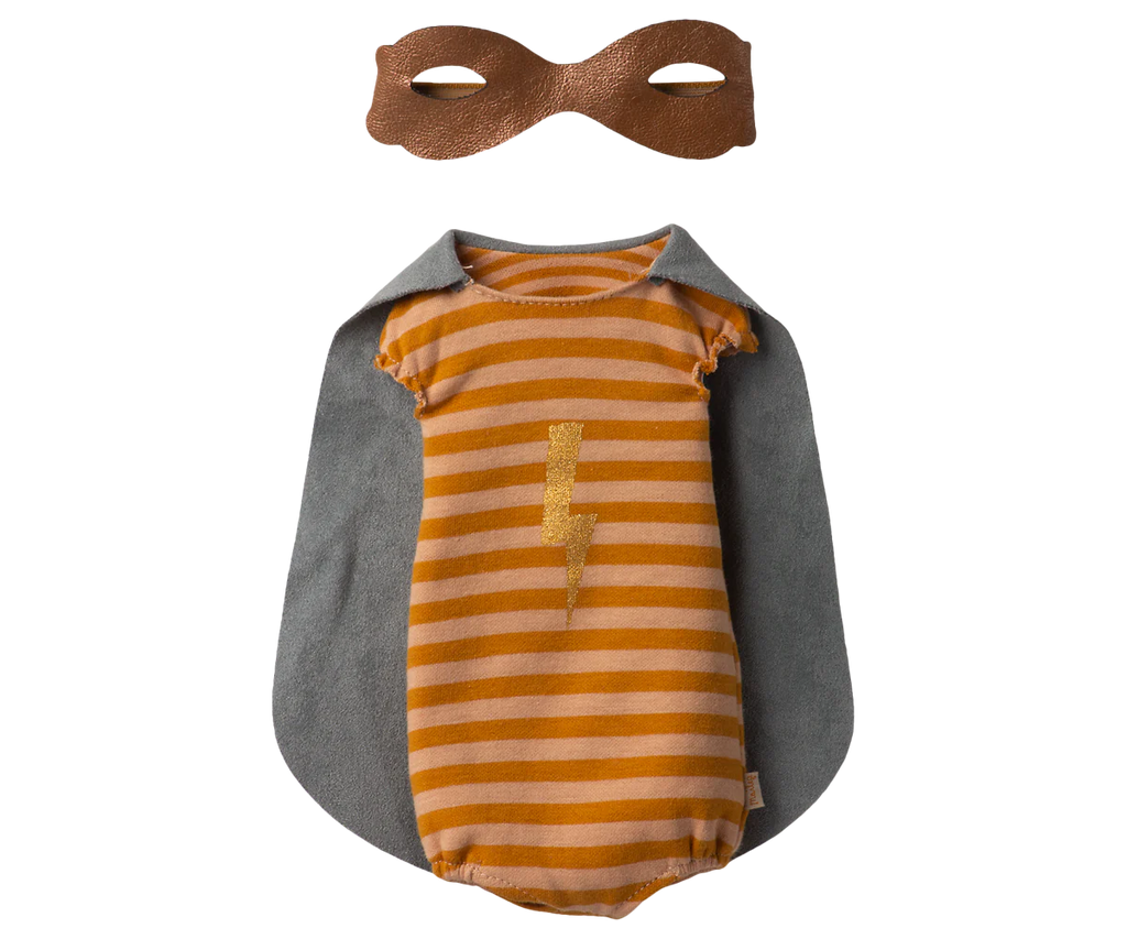 Laid out is the Maileg Superhero Mouse, Maxi - Girl costume, featuring a striped orange onesie with a lightning bolt design and an attached gray cape. Above it sits a brown eye mask, perfect for transforming your child's favorite Maileg Mouse or other beloved toy into the ultimate superhero for their next adventure.