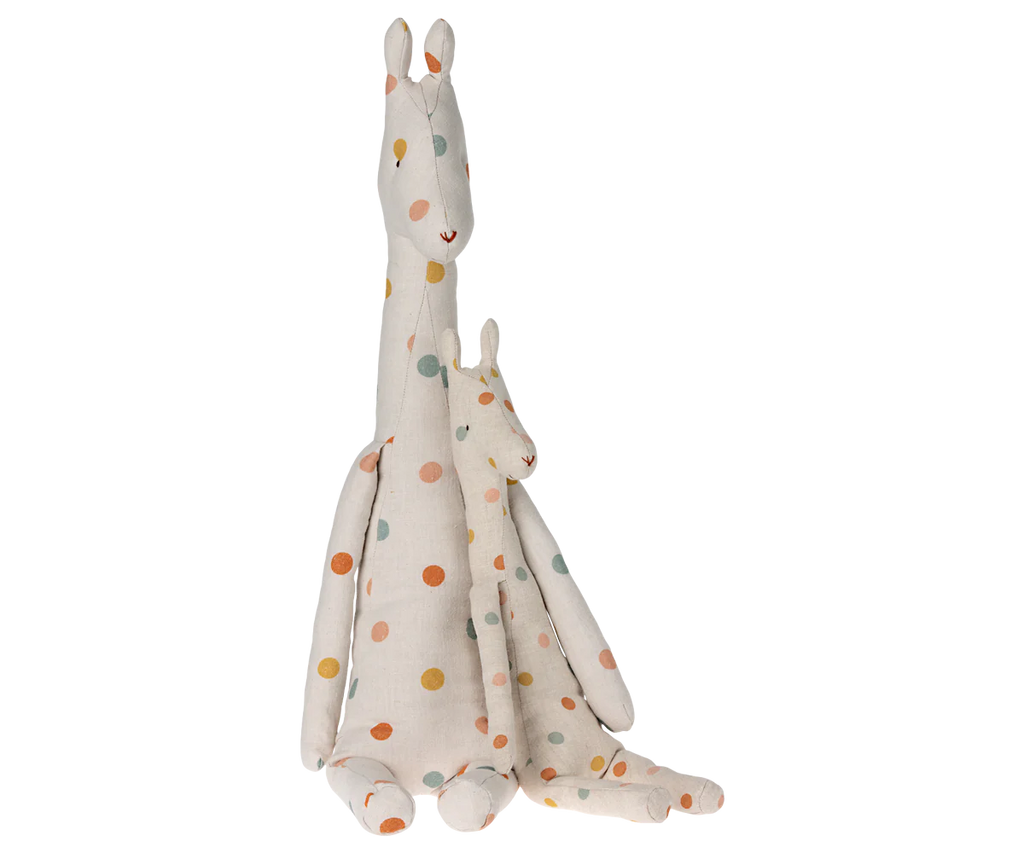 Two Maileg Large Giraffe toys sit side by side, with the larger safari friend behind. Both are white with colorful polka dots in yellow, red, and blue. They have simple stitched facial details and elongated necks that highlight their long giraffe bodies.