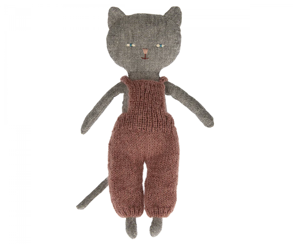 A handmade knitted Maileg Cat Stuffed Animal from the Best Friends collection, with a gray head, green eyes, and wearing a rust-colored jumpsuit, isolated on a white background.