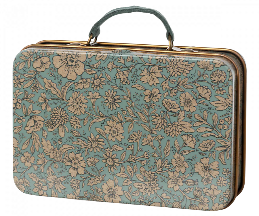 A rectangular vintage-style suitcase with a hinged handle. The suitcase is adorned with an intricate floral pattern featuring cream-colored flowers and leaves on a teal background. Inside, you'll find a matching collar and leash set for your soft plush dog, perfect for stylish travels: the Maileg Puppy Accessories - Blue.