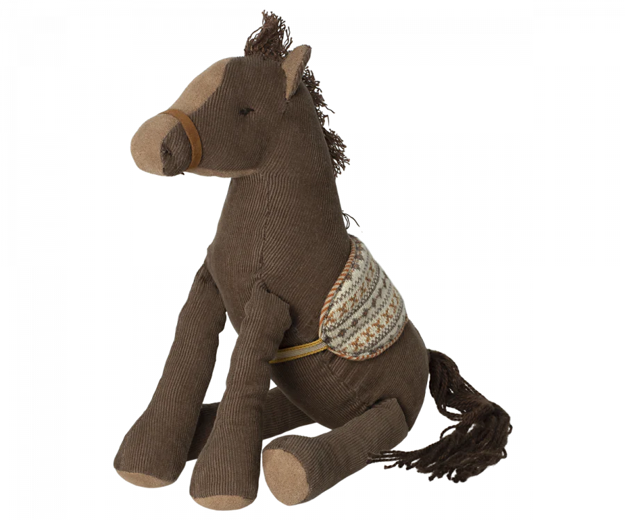 A Maileg Pony (ships in approximately one week) made of corduroy fabric, featuring a darker brown mane and tail, and a patterned fabric saddle. The horse is in a seated position, ready for the adventure of a lifetime.