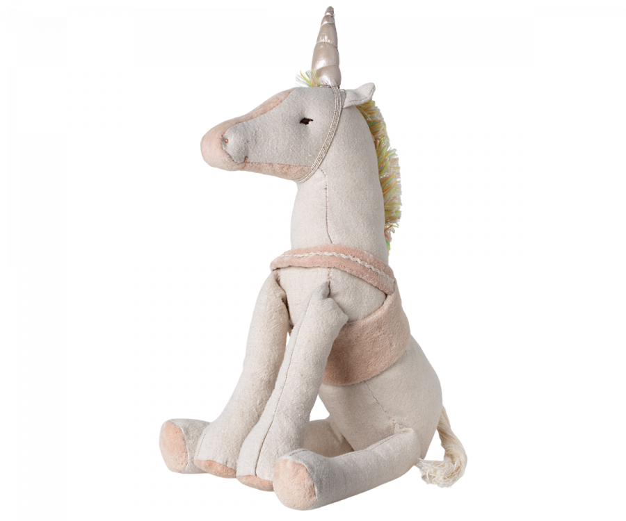 A soft, plush Maileg Unicorn with a golden horn, in a sitting position with pastel mane and tail, predominantly in shades of white and pink, isolated on a white background.
