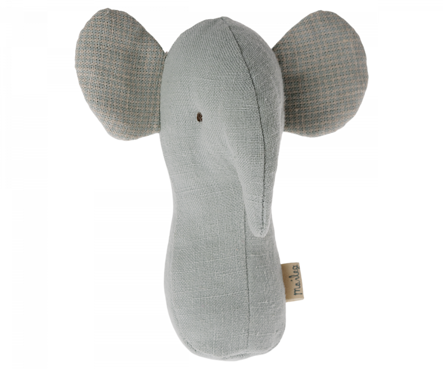 A soft, light gray Maileg Lullaby Friend Rattle, Elephant - Light Dusty Blue, plush toy with large ears, made from a textured fabric. The toy features a simple design with a small embroidered eye and an elongated trunk. A baby rattle is sewn inside for added entertainment, and a tag is attached to the side.