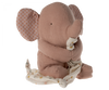 A soft, plush elephant toy with pink fabric and polka-dotted ears holds a cream-colored blanket with gold polka dots. The Maileg Lullaby Friends - Elephant - Old Rose (Plays Music) is sitting and looking to the side, giving a cuddly and endearing appearance, making it an ideal addition to any baby gift box.