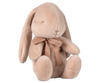 The Maileg Plush Bunny - Light Powder is a soft, plush toy with long ears and a sweet look, featuring closed eyes and a small stitched nose. It sits upright with a brown ribbon around its neck, made from plush fabric and polyester fillings. Available for pre-order, it ships in February.