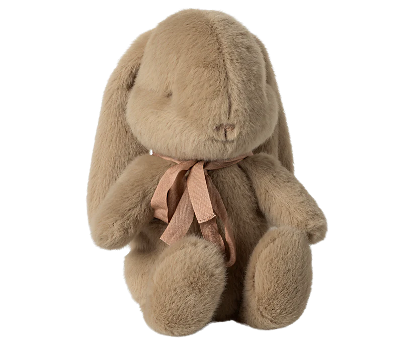 The Maileg Plush Bunny in Carry Cot is a soft dusty brown bunny with long floppy ears, stitched features, and a pink ribbon bow around its neck, sitting upright against a plain white background.