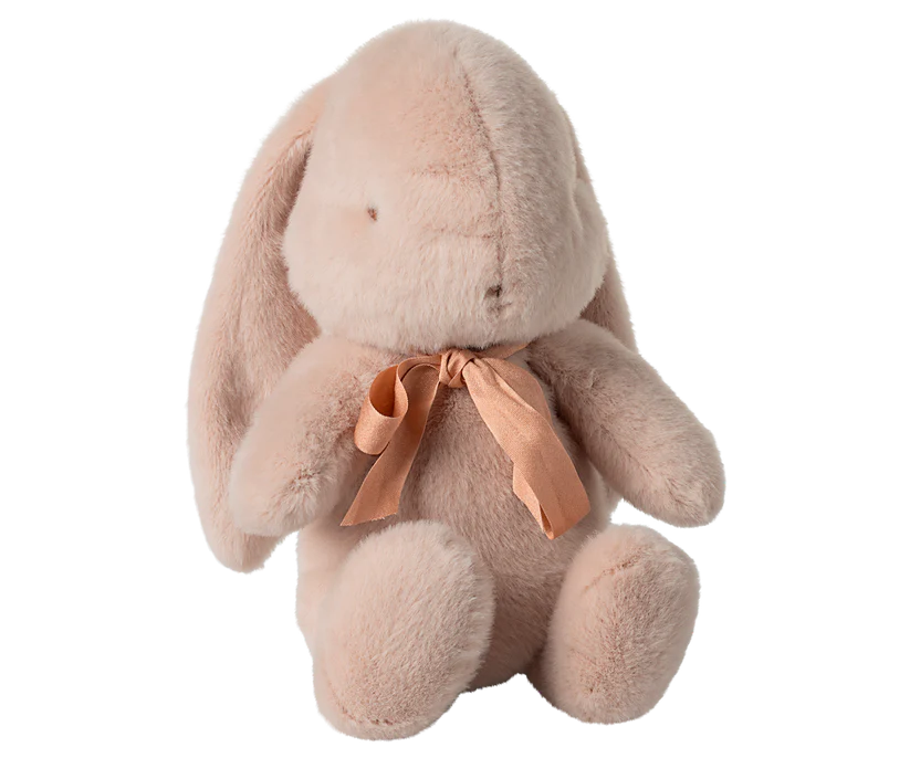 The Maileg Medium Plush Bunny - Powder is a soft, plush toy crafted from recycled polyester, featuring long ears and a pink ribbon around its neck. This light beige bunny sits upright and has an endearing design, making it perfect for cuddles.