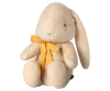 The Maileg Plush Bunny in Medium Cream, available for pre-order and shipping in February, is crafted from recycled polyester. This eco-friendly bunny features long ears, a yellow neck ribbon, and a charmingly simple expression while sitting upright.